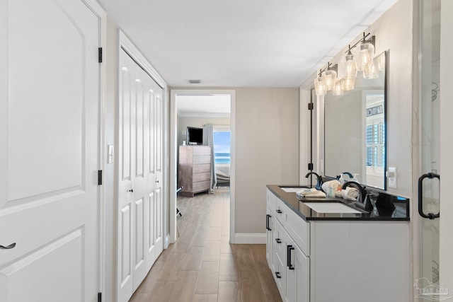 bathroom with ornamental molding, vanity, and hardwood / wood-style flooring