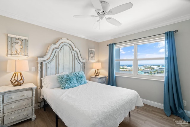 bedroom featuring wood-type flooring, ornamental molding, and ceiling fan