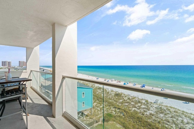 balcony featuring a water view and a view of the beach