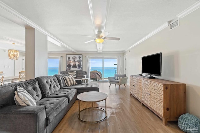 living room with ornamental molding, a wealth of natural light, and light hardwood / wood-style floors