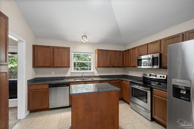 5661 Maggie Rose Cir, Milton, FL 32570 - kitchen featuring stainless steel appliances, light tile patterned flooring, vaulted ceiling, a kitchen island, and dark stone counters