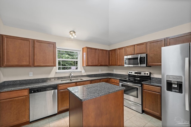 5661 Maggie Rose Cir, Milton, FL 32570 - kitchen with stainless steel appliances, light tile patterned floors, a center island, brown cabinets, and dark stone counters