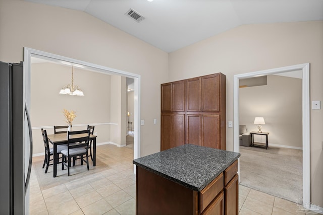 5661 Maggie Rose Cir, Milton, FL 32570 - kitchen featuring freestanding refrigerator, vaulted ceiling, light tile patterned floors, a chandelier, and a kitchen island