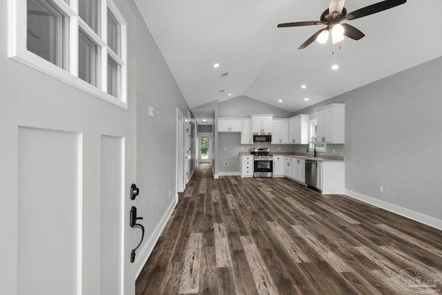 kitchen with dark wood finished floors, ceiling fan, a sink, appliances with stainless steel finishes, and white cabinetry
