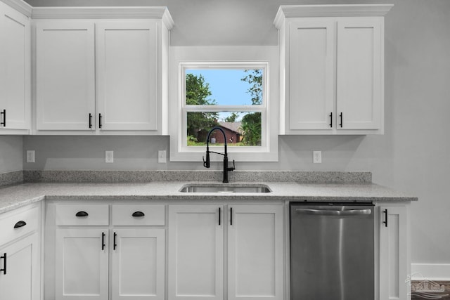 kitchen featuring stainless steel dishwasher, white cabinets, and a sink