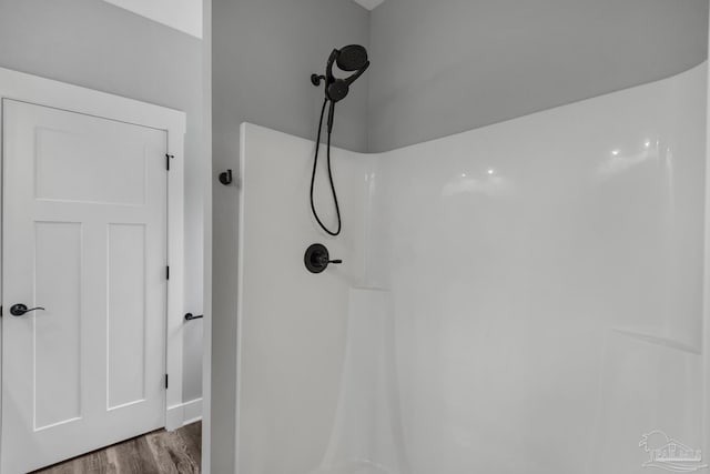 full bath with a shower and wood finished floors