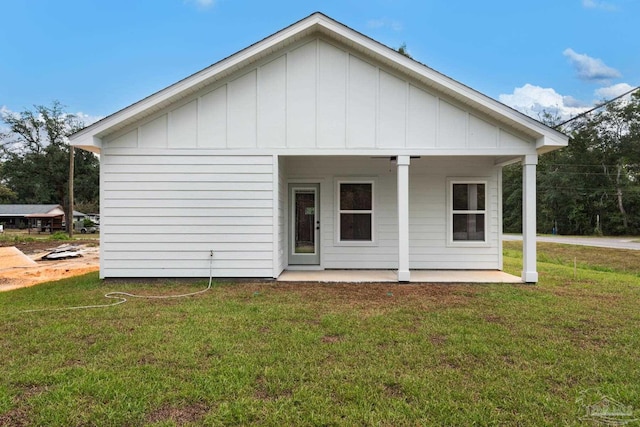 rear view of house featuring a yard and board and batten siding