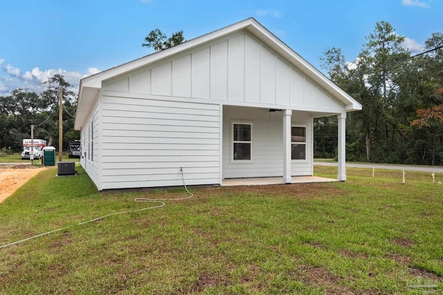 back of property featuring a patio, central AC, a yard, board and batten siding, and ceiling fan