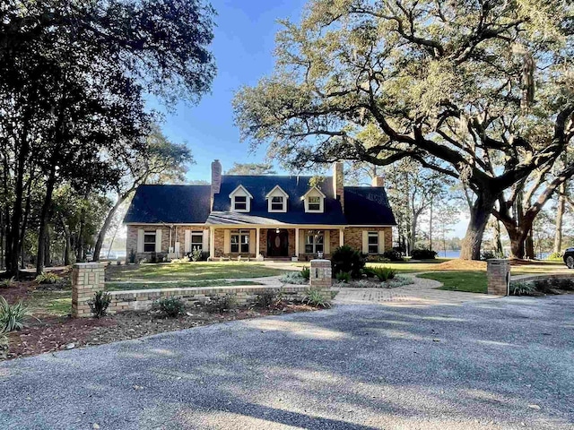 cape cod house featuring a front lawn