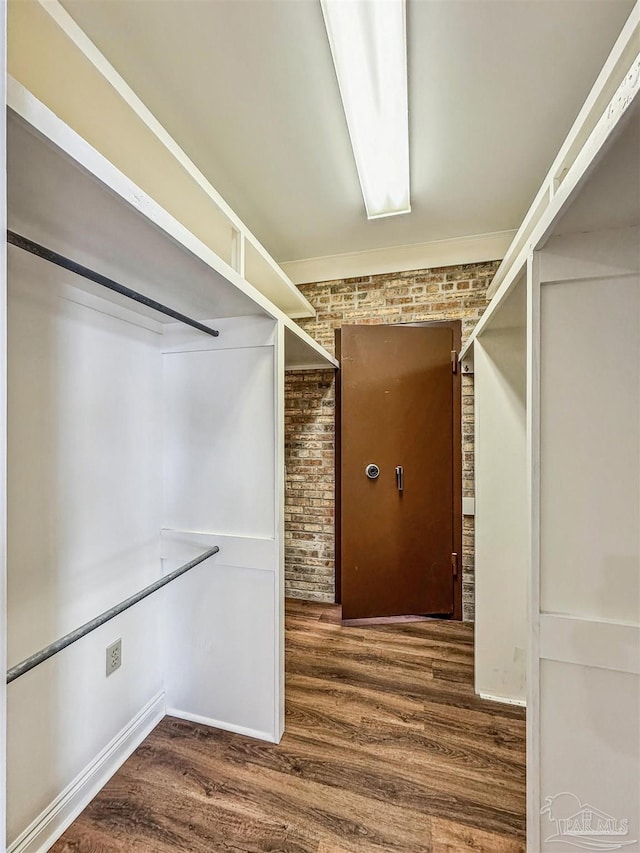 walk in closet with dark hardwood / wood-style flooring