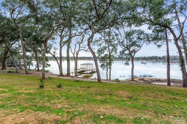 dock area featuring a lawn and a water view