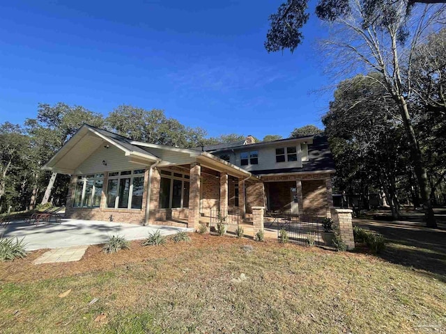 back of house featuring a patio area and a lawn