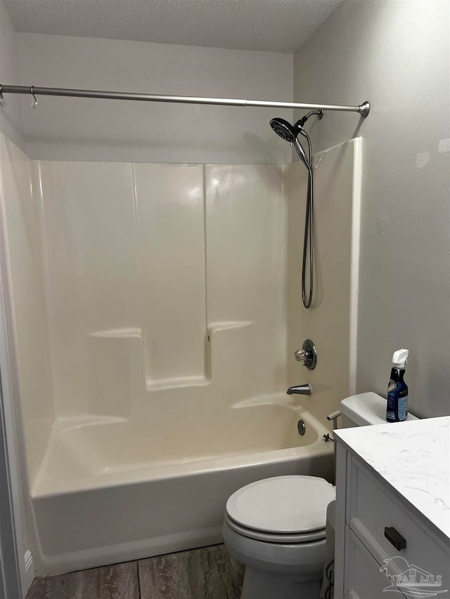 full bathroom featuring shower / bathing tub combination, vanity, toilet, and a textured ceiling