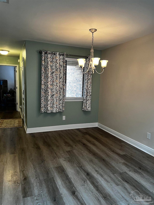 unfurnished dining area featuring dark hardwood / wood-style flooring and a chandelier