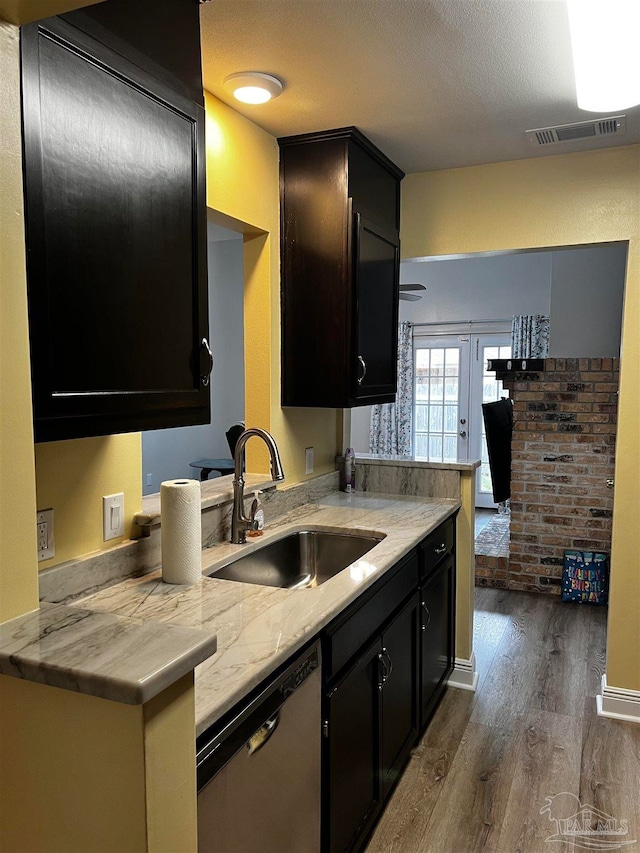 kitchen with sink, stainless steel dishwasher, dark hardwood / wood-style floors, kitchen peninsula, and a textured ceiling