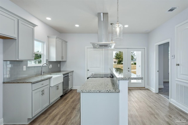 kitchen featuring a kitchen island, dishwasher, decorative backsplash, island exhaust hood, and a sink