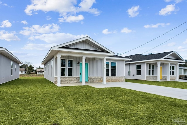 view of front facade with brick siding, board and batten siding, concrete driveway, and a front yard