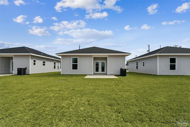 rear view of property featuring cooling unit, french doors, and a lawn