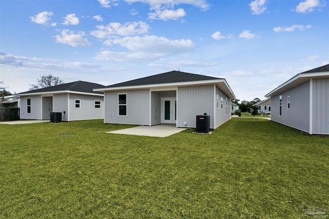 rear view of house with a lawn, central AC, and a patio area