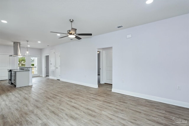 unfurnished living room featuring recessed lighting, baseboards, light wood-style floors, and ceiling fan