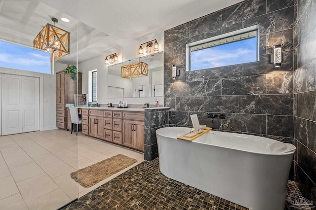 3720 Arbor Ridge Rd, Pace, FL 32571 - full bath with tile patterned flooring, double vanity, tile walls, a soaking tub, and a notable chandelier