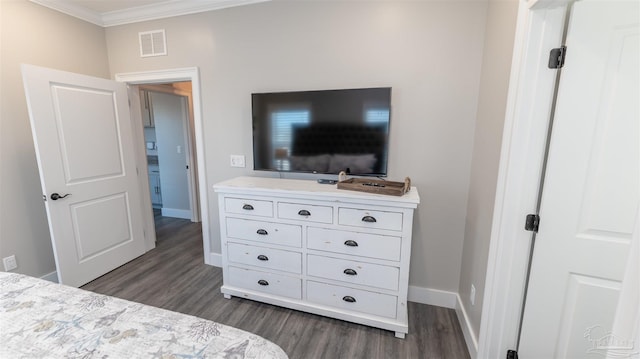 bedroom with ornamental molding and dark hardwood / wood-style floors