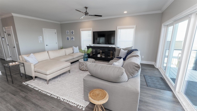 living room with a healthy amount of sunlight, dark hardwood / wood-style flooring, and crown molding