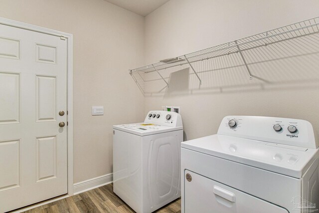 laundry area featuring separate washer and dryer and wood-type flooring