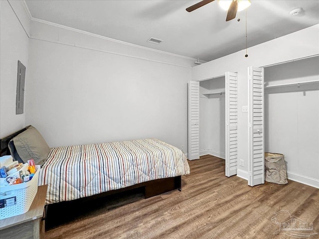 1007 W Wright St, Pensacola, FL 32501 - bedroom featuring electric panel, ornamental molding, multiple closets, visible vents, and wood finished floors