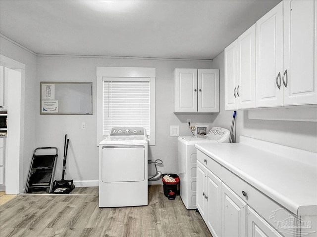 1007 W Wright St, Pensacola, FL 32501 - laundry room with cabinet space, light wood-style floors, and separate washer and dryer