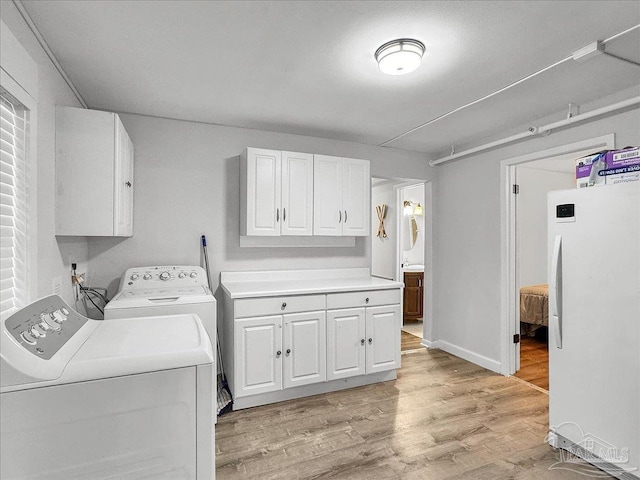 1007 W Wright St, Pensacola, FL 32501 - washroom featuring baseboards, cabinet space, light wood-style flooring, and washer and dryer
