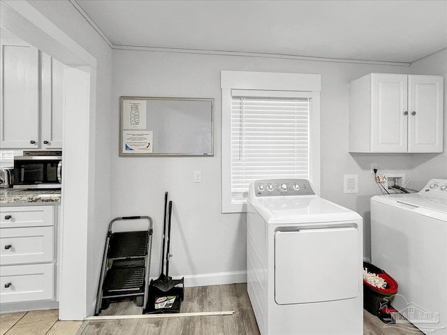 1007 W Wright St, Pensacola, FL 32501 - laundry room featuring baseboards, washing machine and dryer, cabinet space, and light wood-type flooring