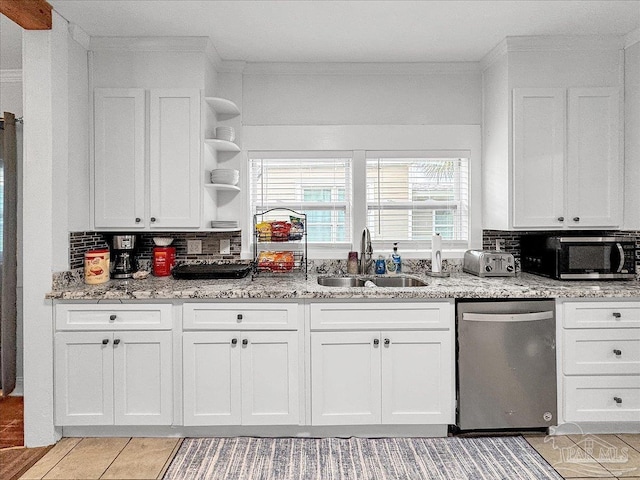 1007 W Wright St, Pensacola, FL 32501 - kitchen with stainless steel dishwasher, white cabinetry, tasteful backsplash, and a sink