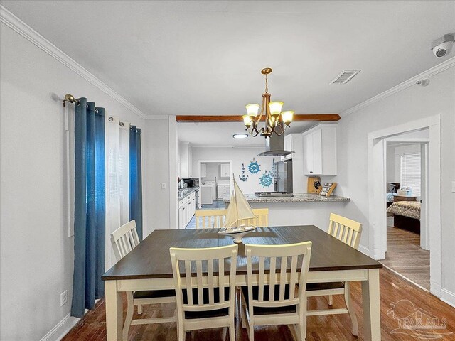1007 W Wright St, Pensacola, FL 32501 - dining room with ornamental molding, visible vents, an inviting chandelier, and wood finished floors