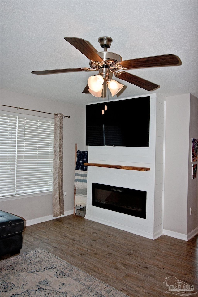 9453 Lutoo Ln, Pensacola, FL 32526 - living area featuring a fireplace, baseboards, wood finished floors, a ceiling fan, and a textured ceiling