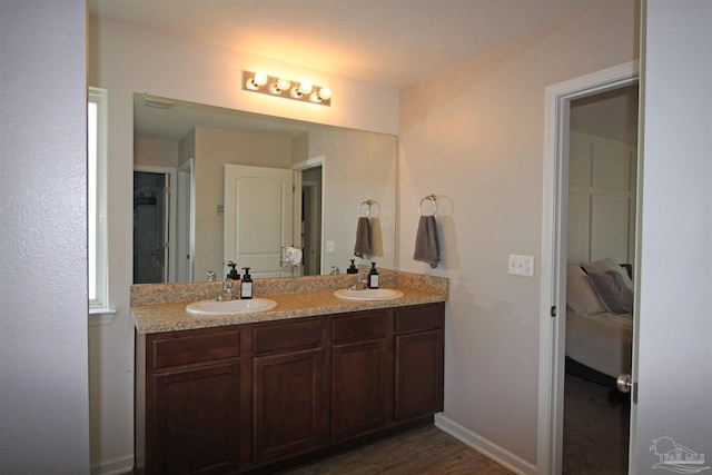 9453 Lutoo Ln, Pensacola, FL 32526 - bathroom with double vanity, wood finished floors, and baseboards