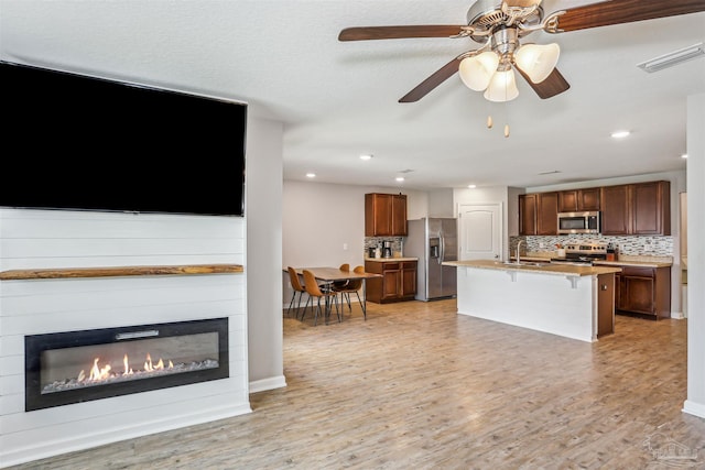 9453 Lutoo Ln, Pensacola, FL 32526 - kitchen with appliances with stainless steel finishes, a sink, backsplash, a breakfast bar, and recessed lighting
