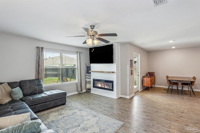 9453 Lutoo Ln, Pensacola, FL 32526 - living area with baseboards, wood finished floors, ceiling fan, and a fireplace