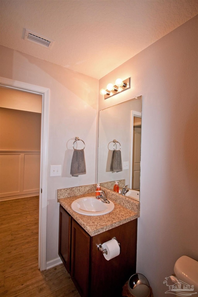 9453 Lutoo Ln, Pensacola, FL 32526 - half bathroom featuring vanity, wood finished floors, and toilet