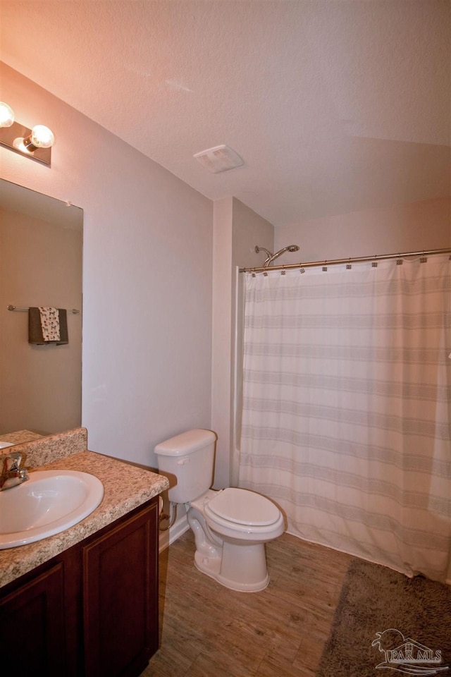 9453 Lutoo Ln, Pensacola, FL 32526 - bathroom with vanity, wood finished floors, toilet, and a shower with shower curtain