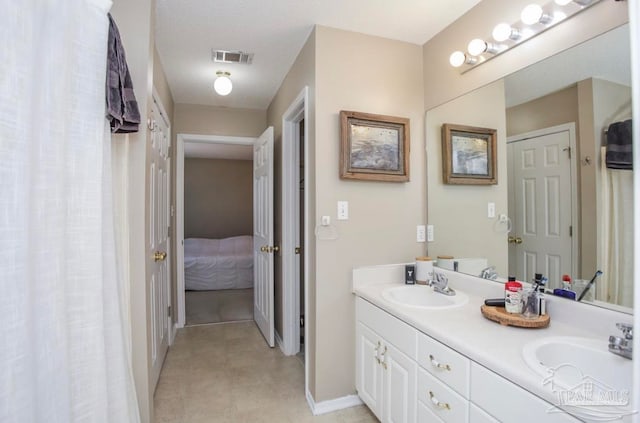 bathroom with tile patterned floors and double sink vanity