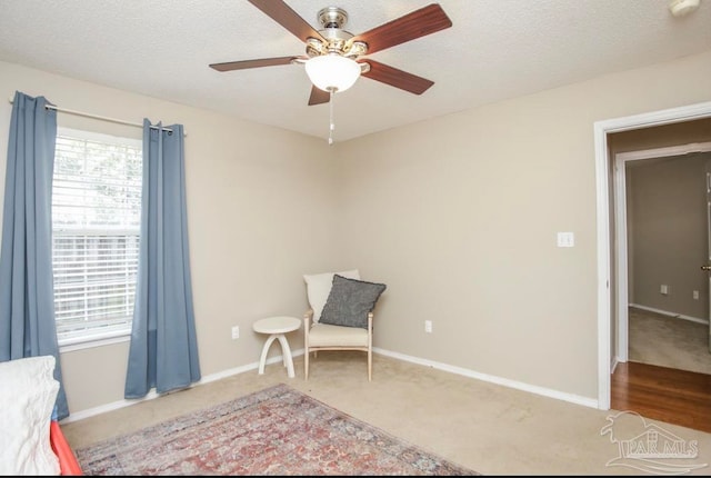 unfurnished room featuring a textured ceiling, carpet, and ceiling fan