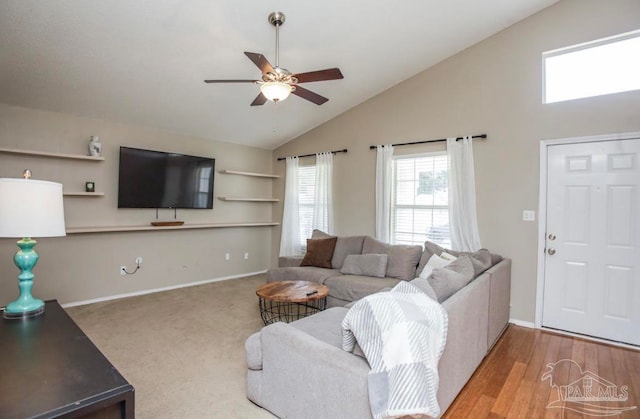 living room with ceiling fan, high vaulted ceiling, and light colored carpet