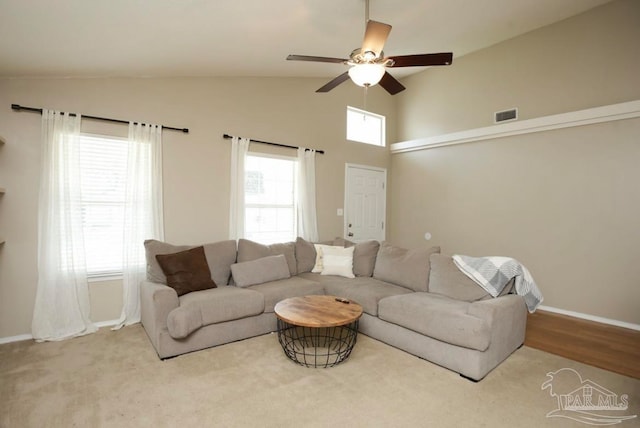 carpeted living room featuring ceiling fan and vaulted ceiling