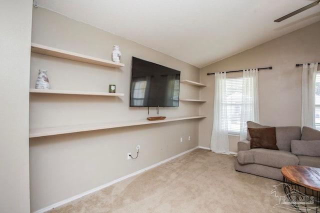 living room featuring ceiling fan, lofted ceiling, and light carpet