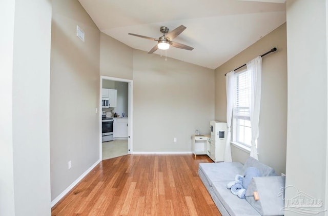 unfurnished living room featuring ceiling fan, vaulted ceiling, and light hardwood / wood-style floors