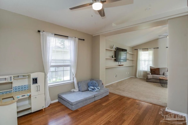 sitting room featuring carpet flooring, vaulted ceiling, ceiling fan, and a healthy amount of sunlight