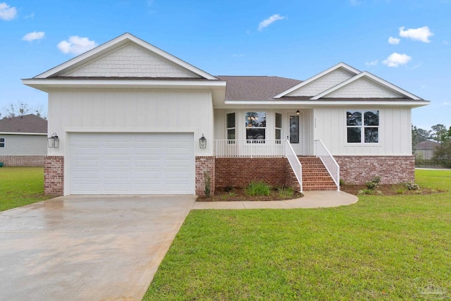 view of front of house featuring a garage, a front lawn, and covered porch