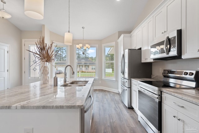 kitchen featuring sink, stainless steel appliances, hardwood / wood-style floors, and an island with sink