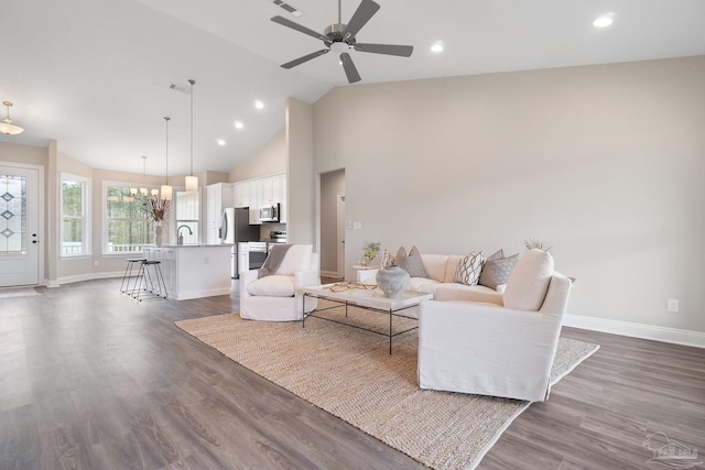 living room with dark wood-type flooring, ceiling fan, and high vaulted ceiling